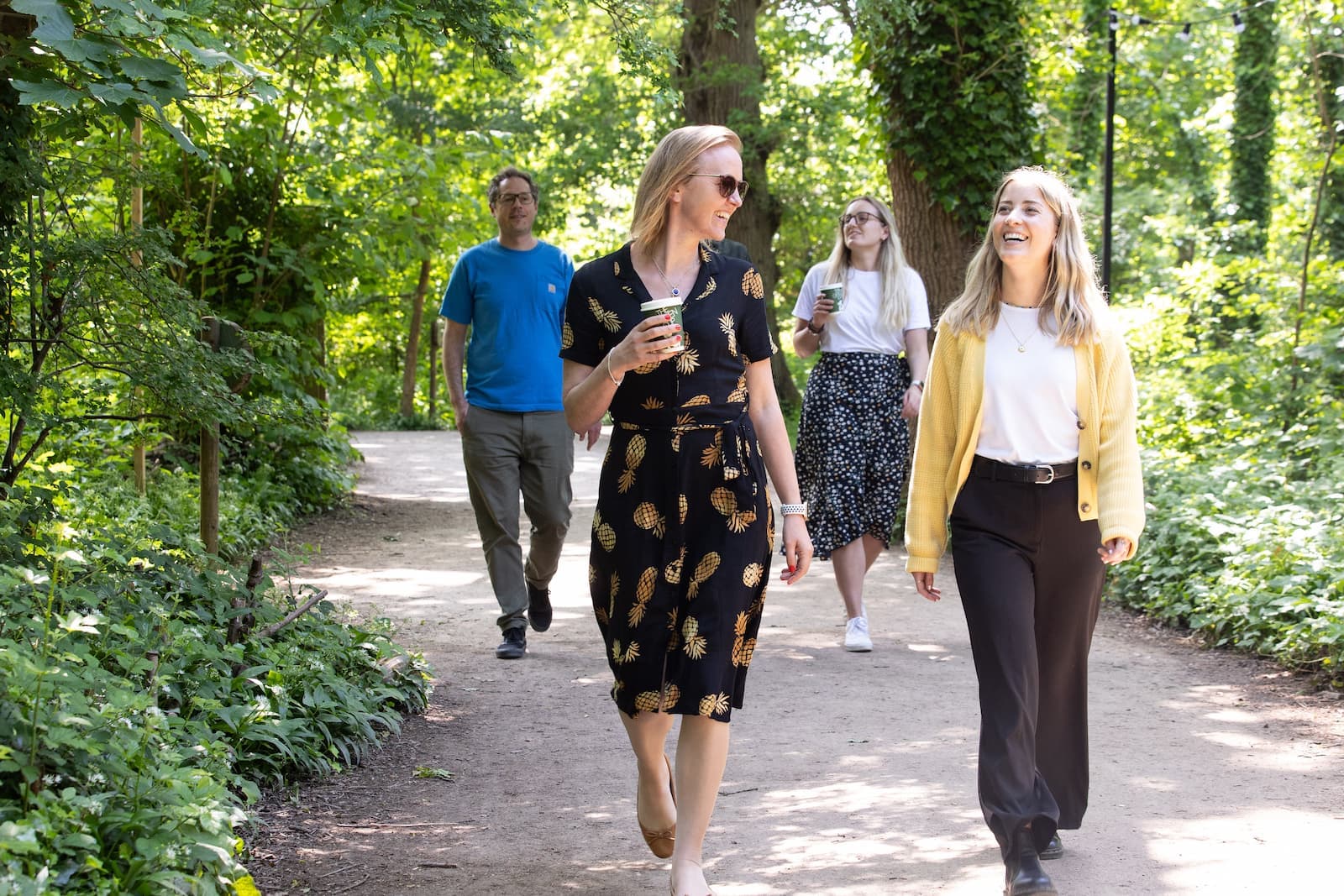 A group of people walk along a path in woodland