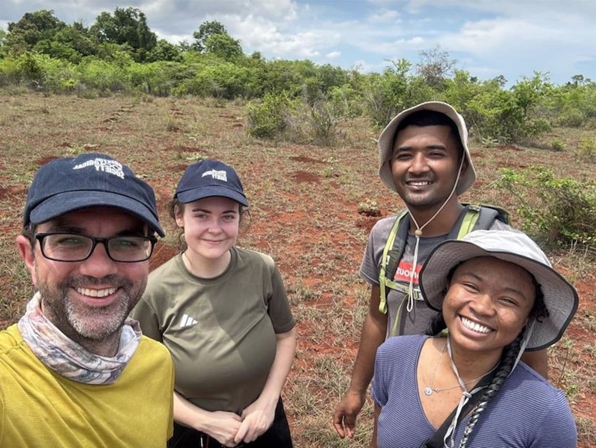 Four people smiling at the camera while stood outside